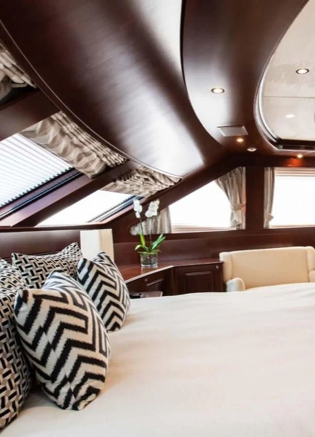 a bed with pillows and a window aboard MI AMORE JULIA Yacht for Sale