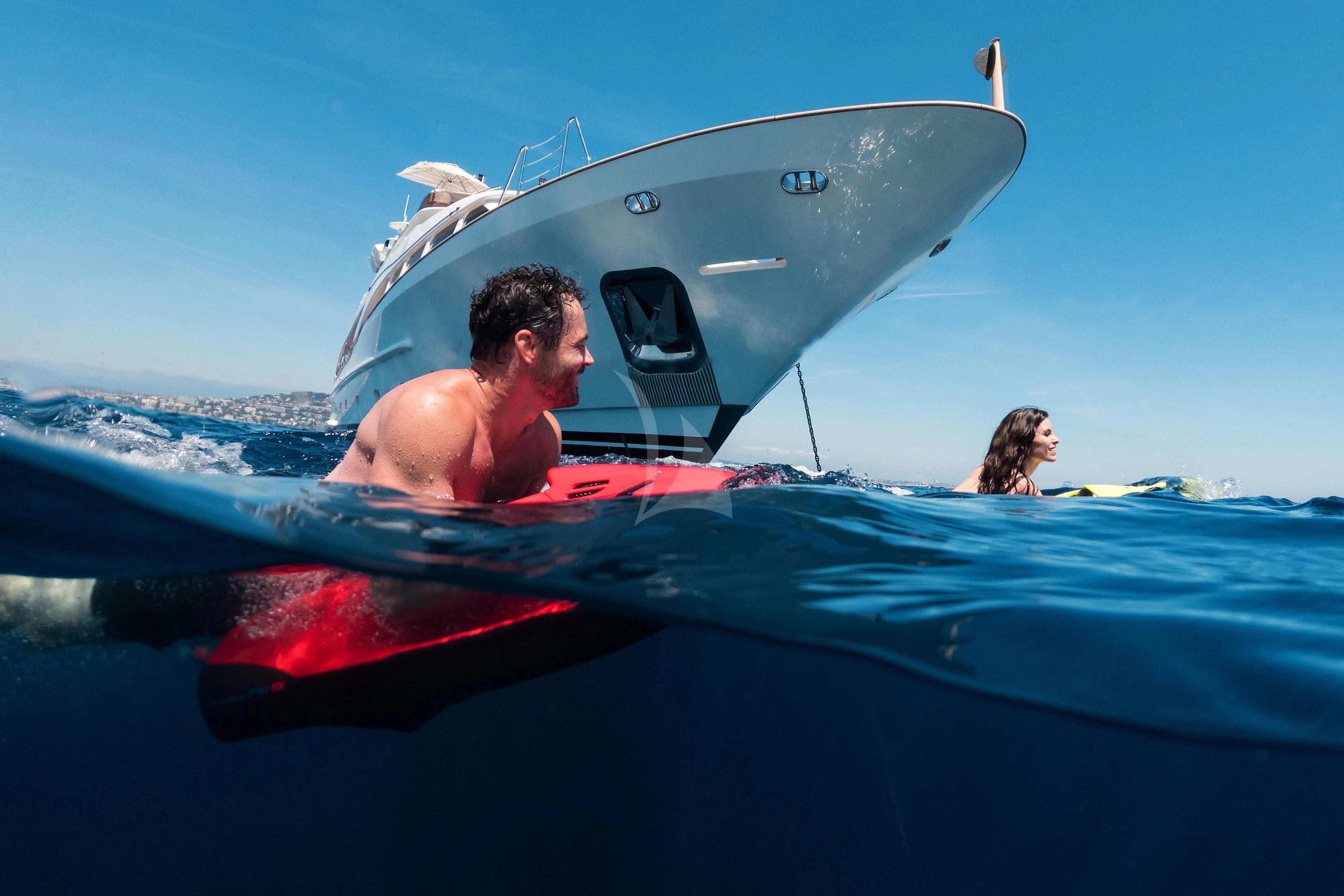 a man and woman on a surfboard in the ocean aboard MI AMORE JULIA Yacht for Sale