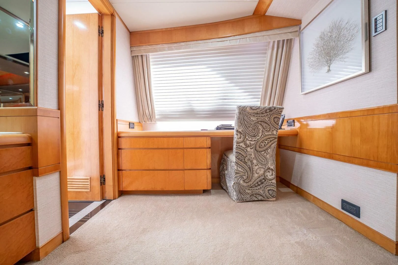 a cat sitting on a chair in a room with a dresser and a window aboard ISLAND HEIRESS Yacht for Charter