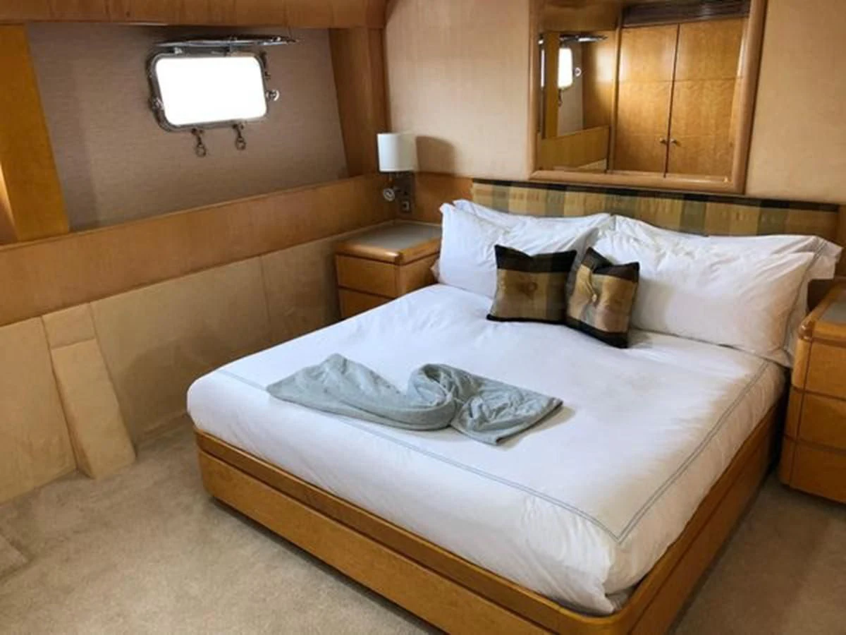 a bed with white sheets and pillows aboard ISLAND HEIRESS Yacht for Charter