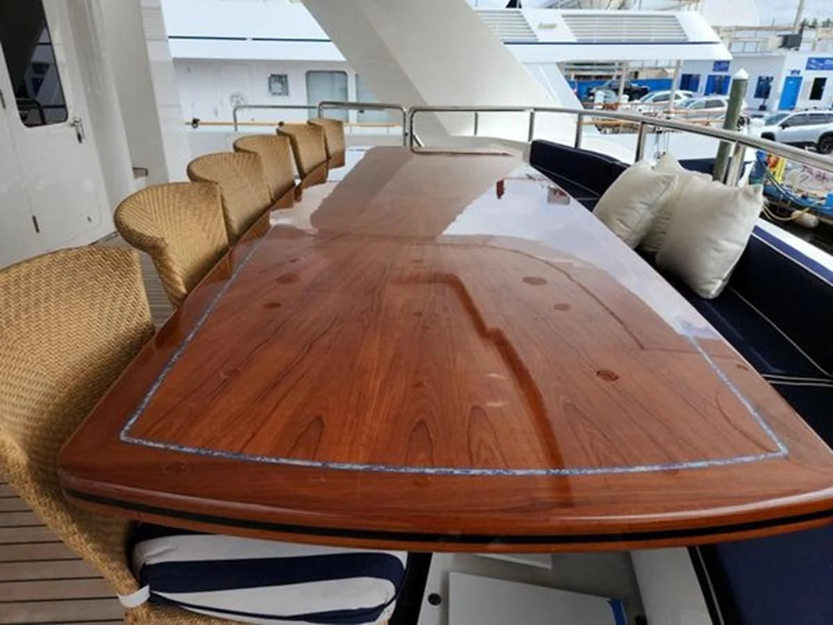 a wooden table with a couch and chairs in a room with a window aboard ISLAND HEIRESS Yacht for Charter