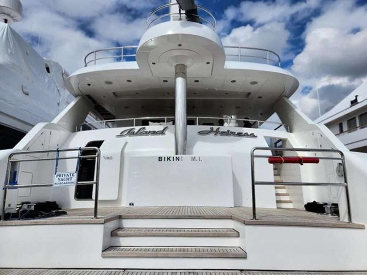 a white ship with a red stripe aboard ISLAND HEIRESS Yacht for Charter