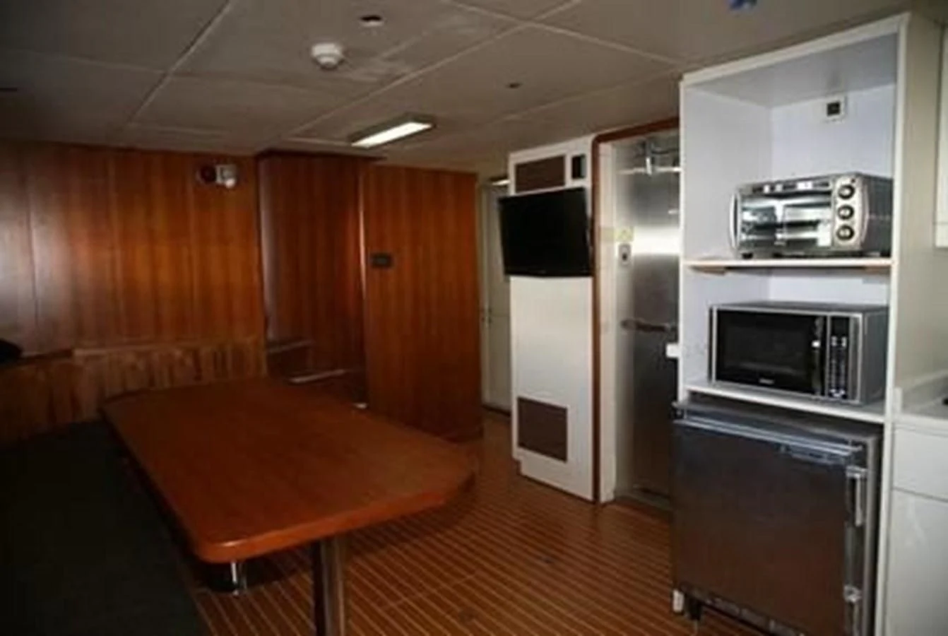 a room with a table and a tv aboard ISLAND HEIRESS Yacht for Charter