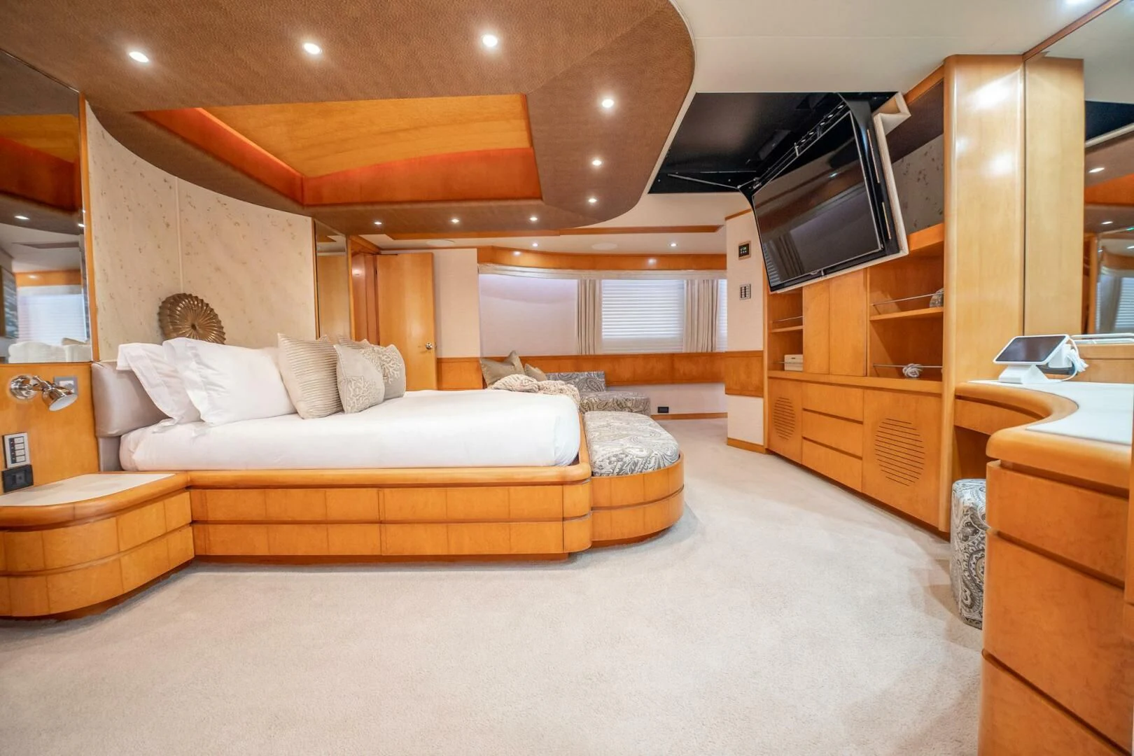 a large room with a bed and a wood cabinet aboard ISLAND HEIRESS Yacht for Charter