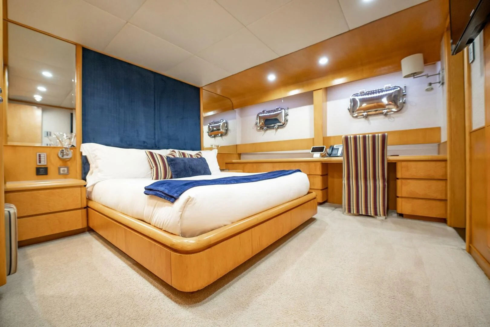 a bedroom with a bed and a dresser aboard ISLAND HEIRESS Yacht for Charter