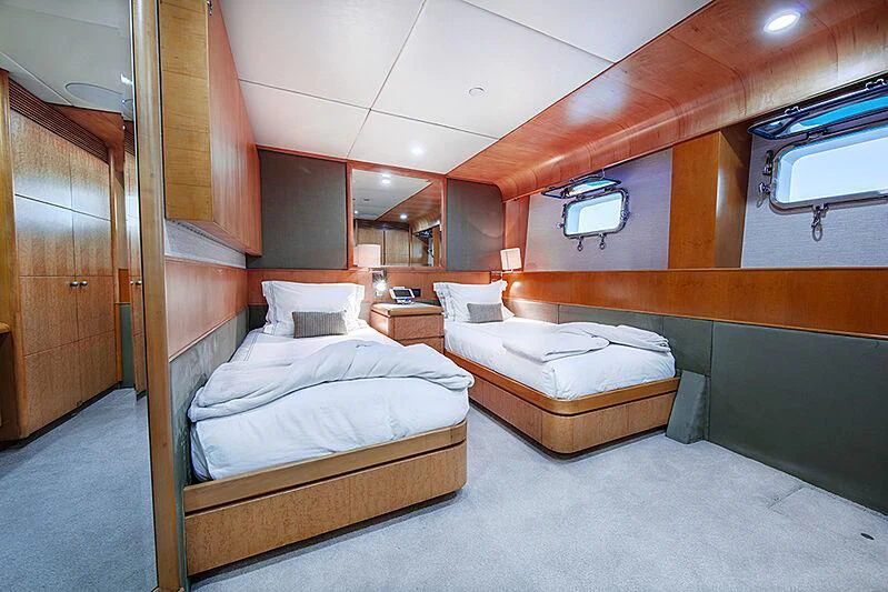 a room with beds and a wood door aboard ISLAND HEIRESS Yacht for Charter