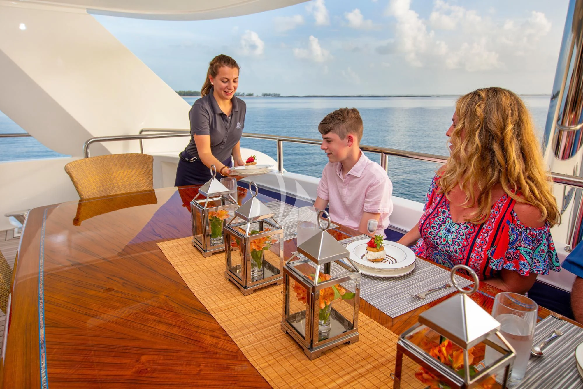 a group of people sitting at a table with food and drinks on it aboard ISLAND HEIRESS Yacht for Charter