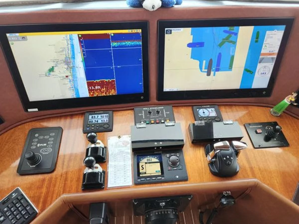 a desk with a computer and several electronics on it aboard ISLAND HEIRESS Yacht for Charter