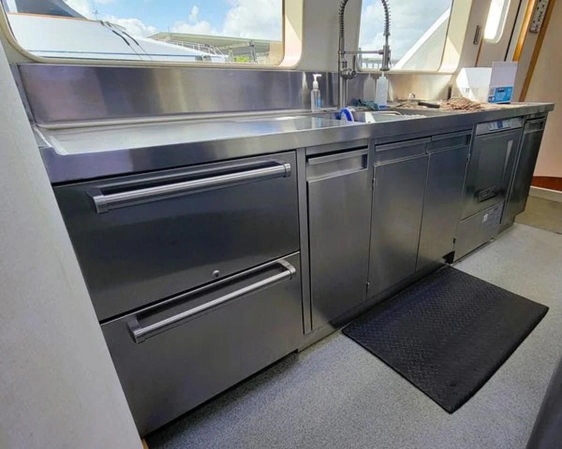 a kitchen with a black counter aboard ISLAND HEIRESS Yacht for Charter