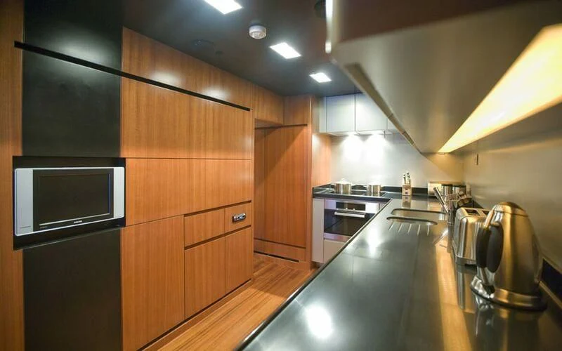 a kitchen with wooden cabinets aboard NEW VOGUE Yacht for Sale