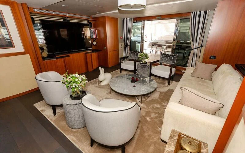a living room with a couch and a television aboard NEW VOGUE Yacht for Sale