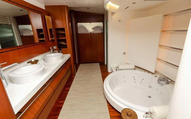 a bathroom with a tub sink and a mirror aboard NEW VOGUE Yacht for Sale