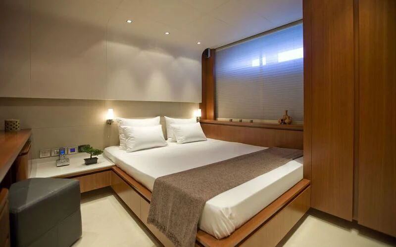 a room with a bed and a desk aboard NEW VOGUE Yacht for Sale