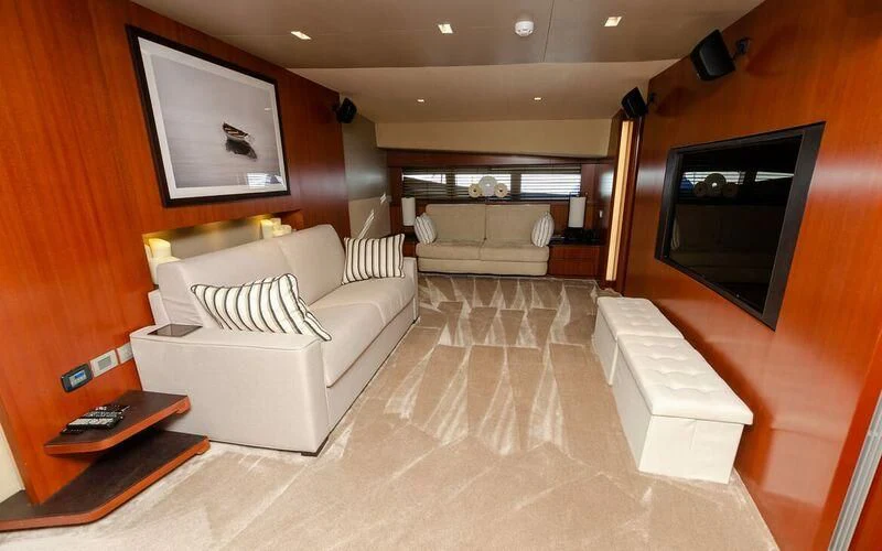 a living room with a couch and a television aboard NEW VOGUE Yacht for Sale