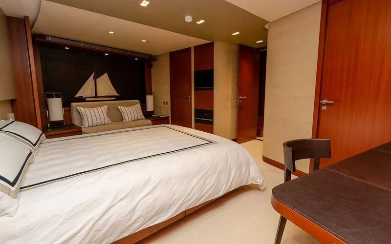a hotel room with a bed and desk aboard NEW VOGUE Yacht for Sale