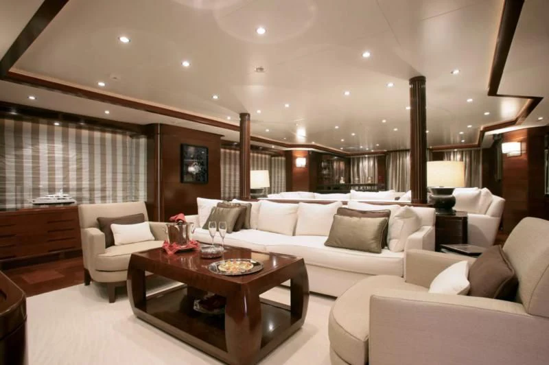 a large living room with a large white sofa and a wood coffee table aboard SEASCAPE V Yacht for Sale