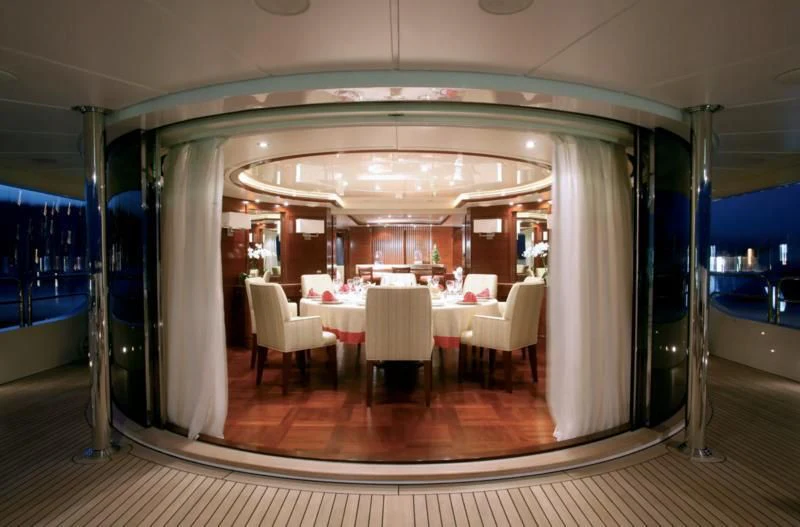 a room with tables and chairs aboard SEASCAPE V Yacht for Sale
