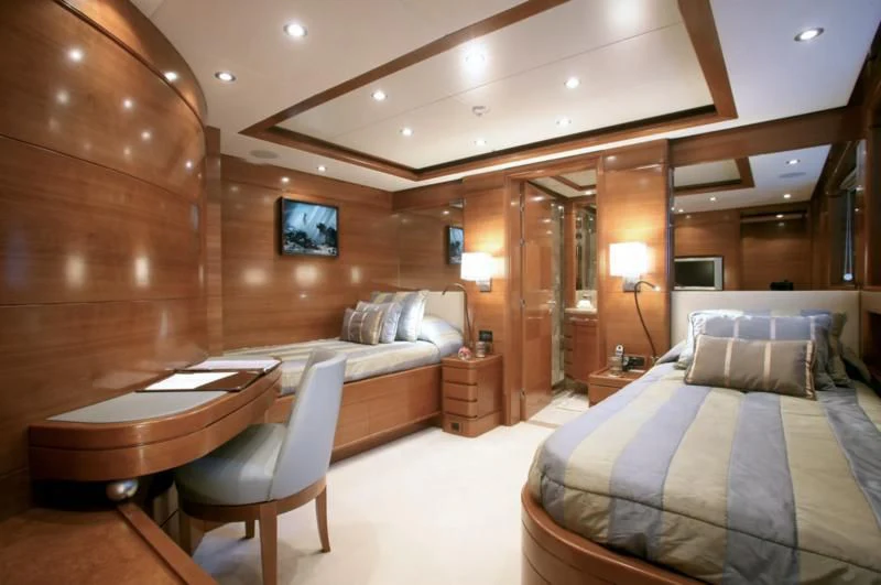 a room with a bed and a table aboard SEASCAPE V Yacht for Sale