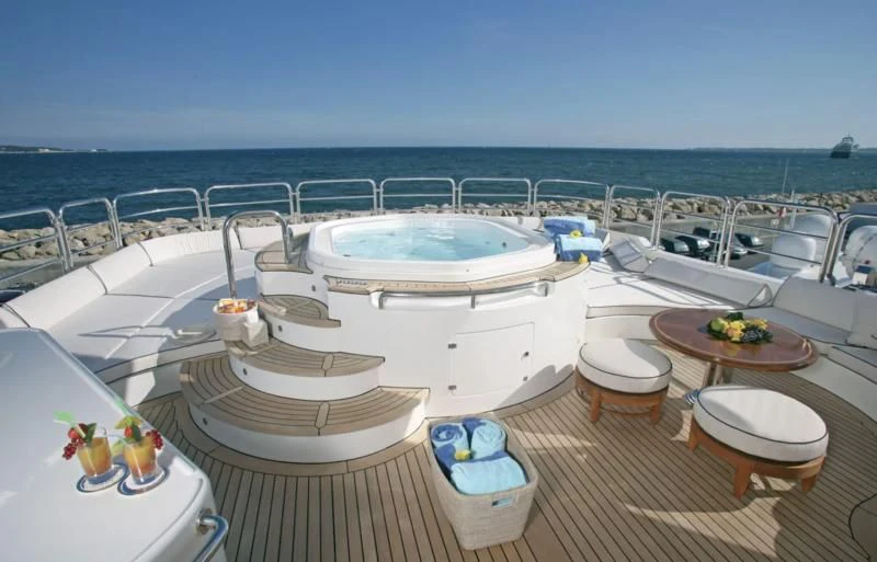 a lounge area with a lounge chair and a pool aboard SEASCAPE V Yacht for Sale