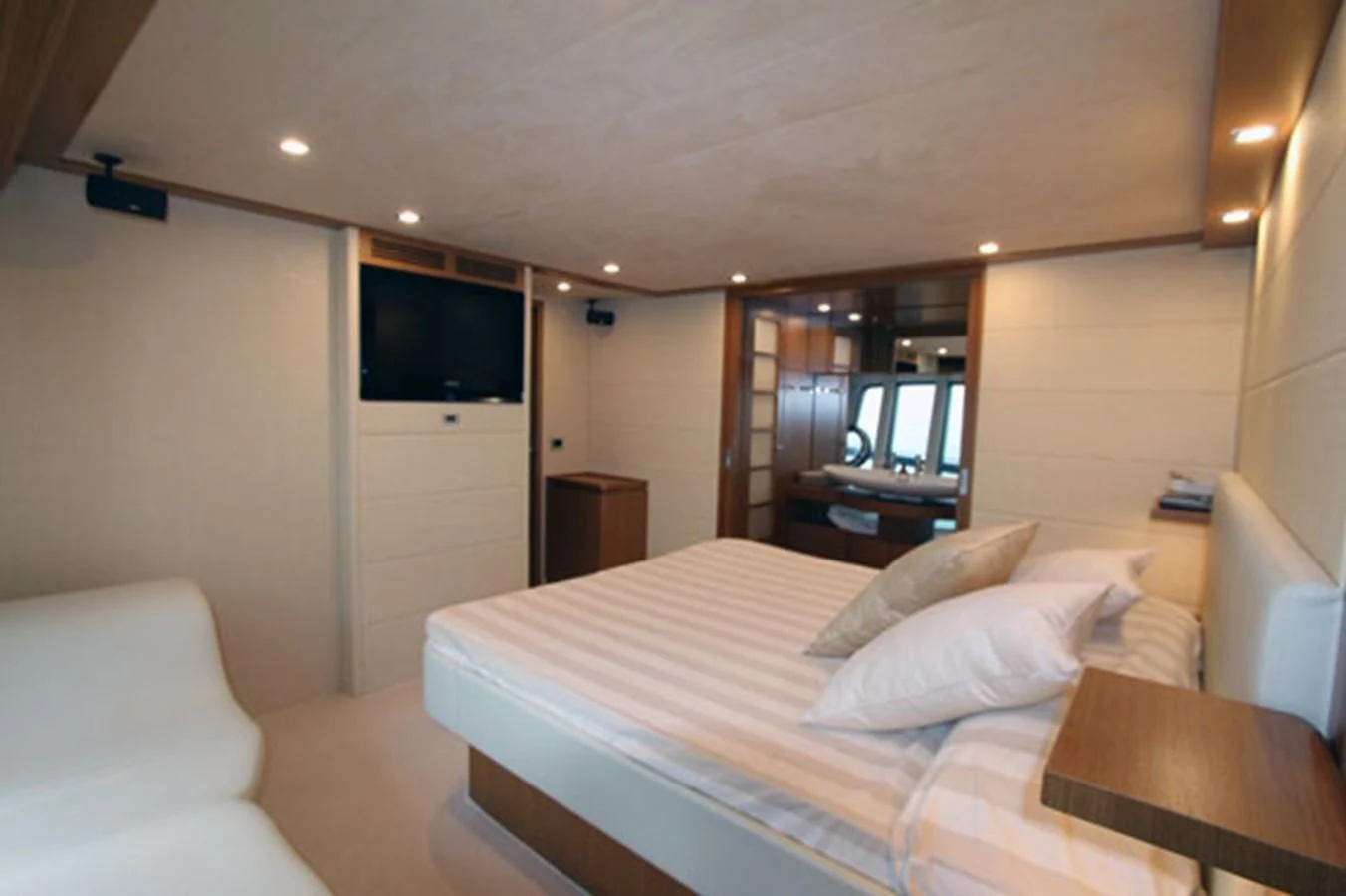a hotel room with a bed and a television aboard ARGO Yacht for Sale