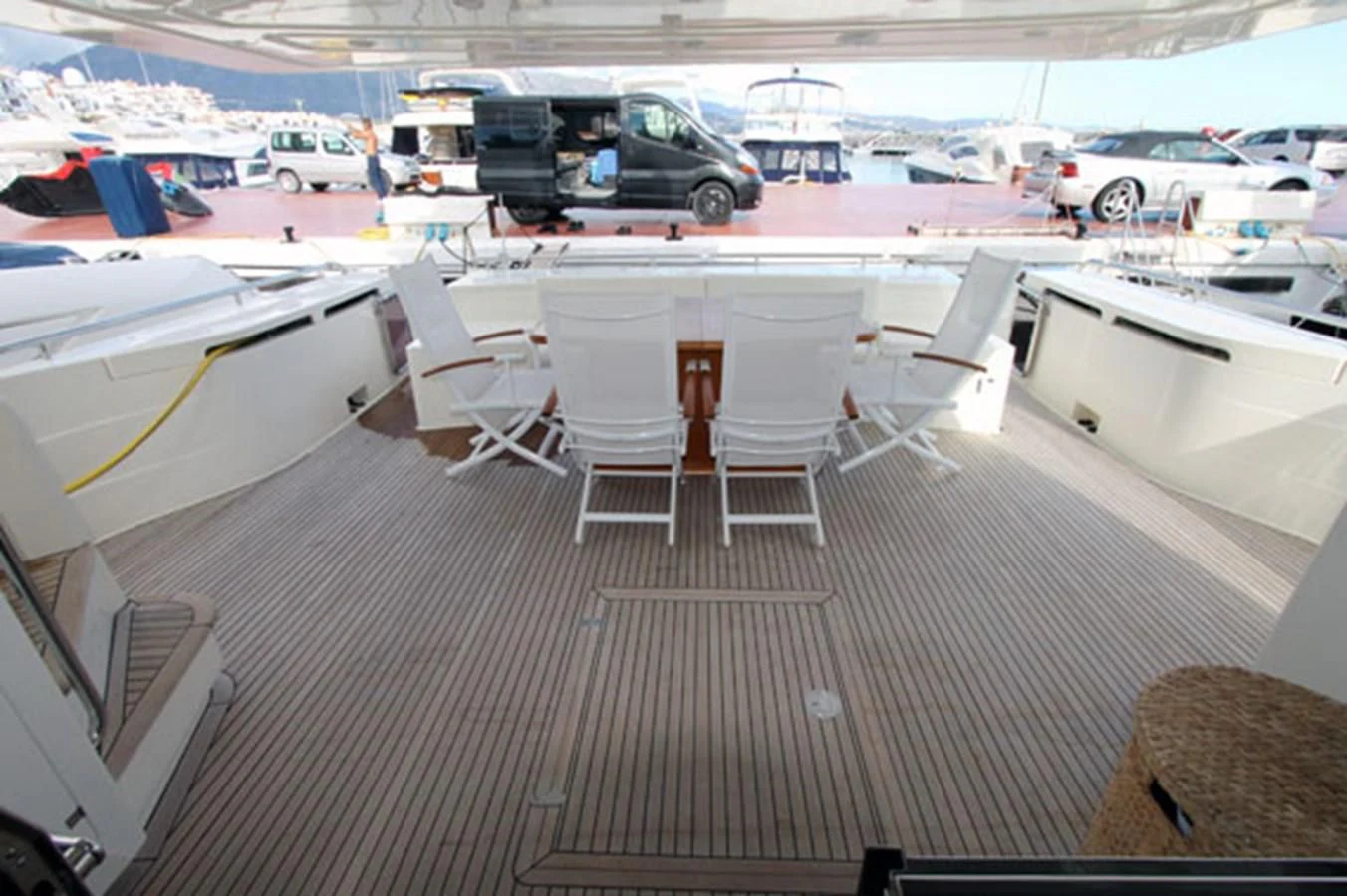 a deck with a group of chairs and a table with a van in the background aboard ARGO Yacht for Sale