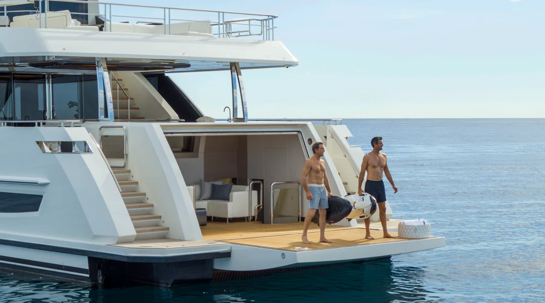 a couple of men walking on a boat with a dog aboard MÖBIUS Yacht for Sale
