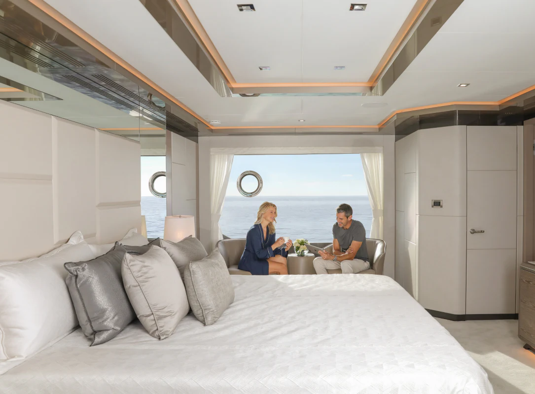 a couple sitting on a bed aboard MÖBIUS Yacht for Sale