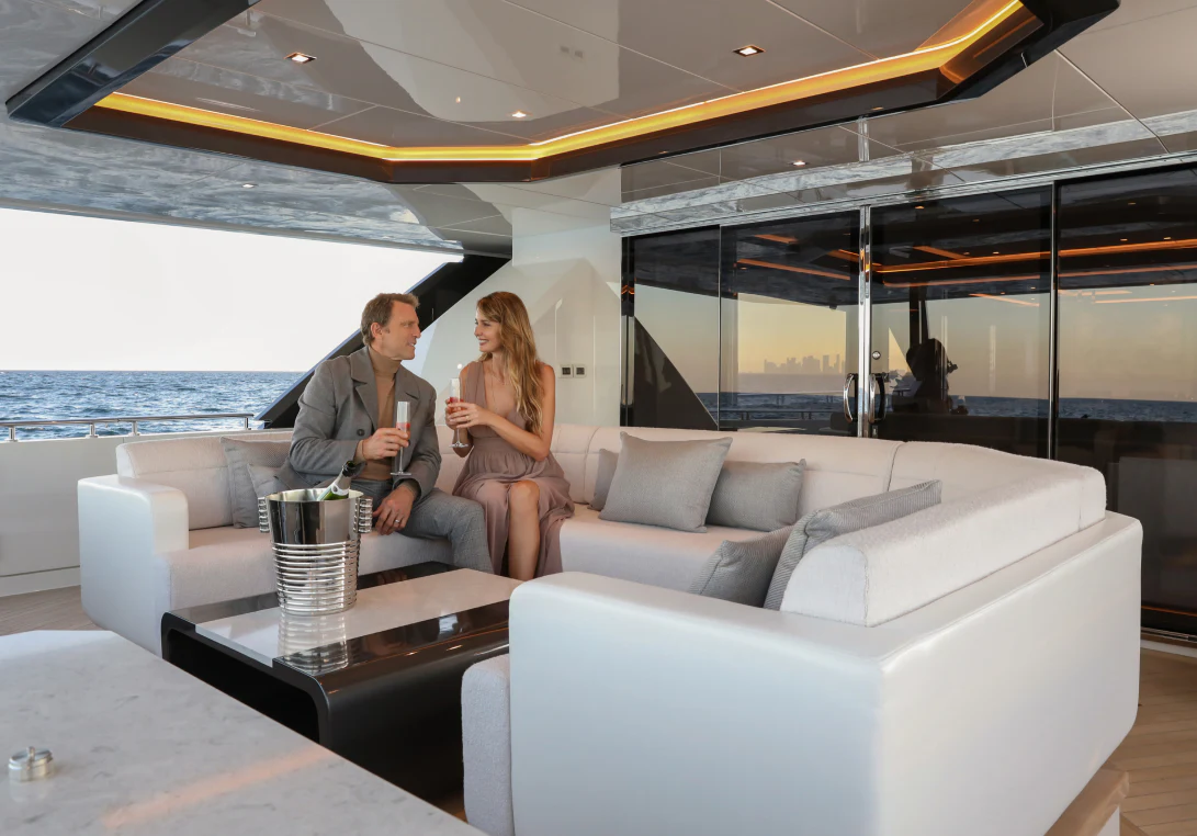 a group of people sitting on a couch in front of a large window aboard MÖBIUS Yacht for Sale