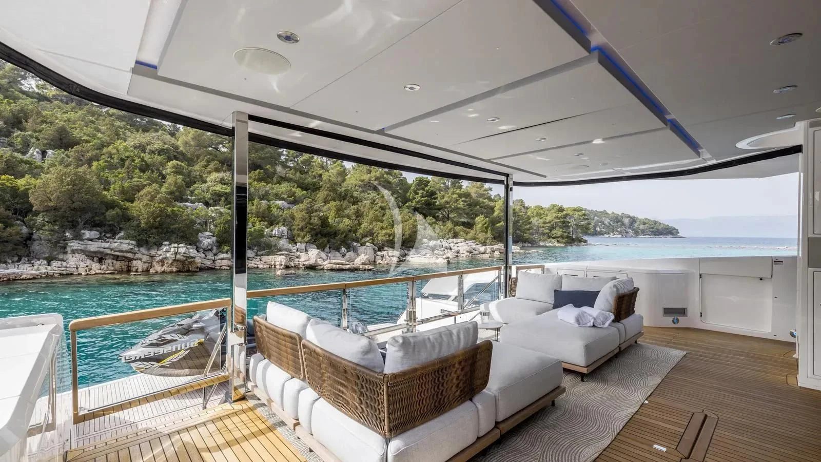a large swimming pool with a deck and a deck with a view of the water and trees aboard EXIT Yacht for Sale