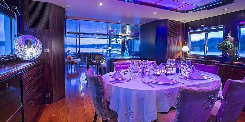 a dining room with a table set for a dinner aboard PAOLYRE Yacht for Sale