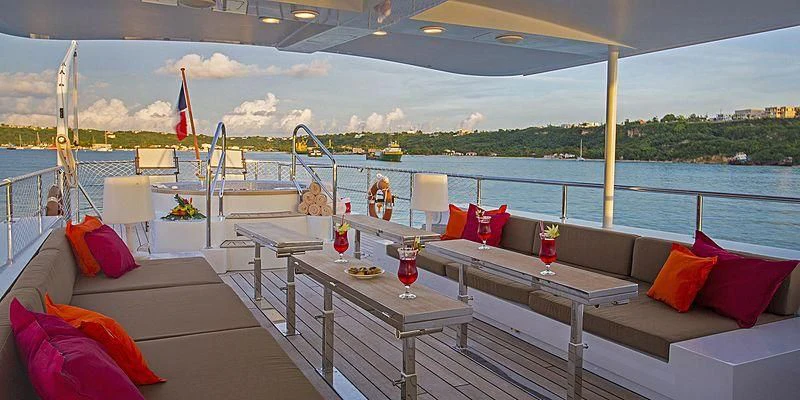 a deck with a table and chairs on it and a body of water in the background aboard PAOLYRE Yacht for Sale