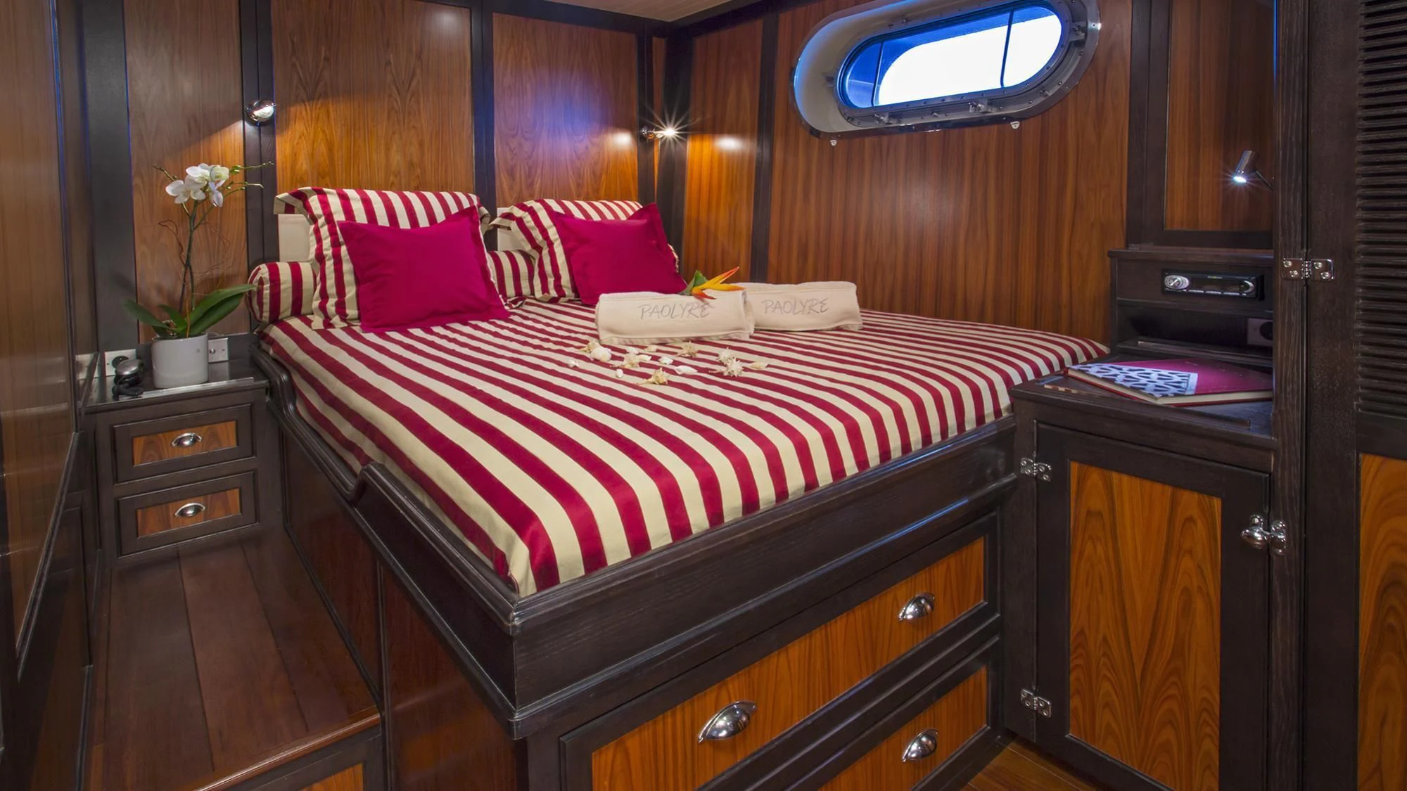 a bed with red and white pillows aboard PAOLYRE Yacht for Sale
