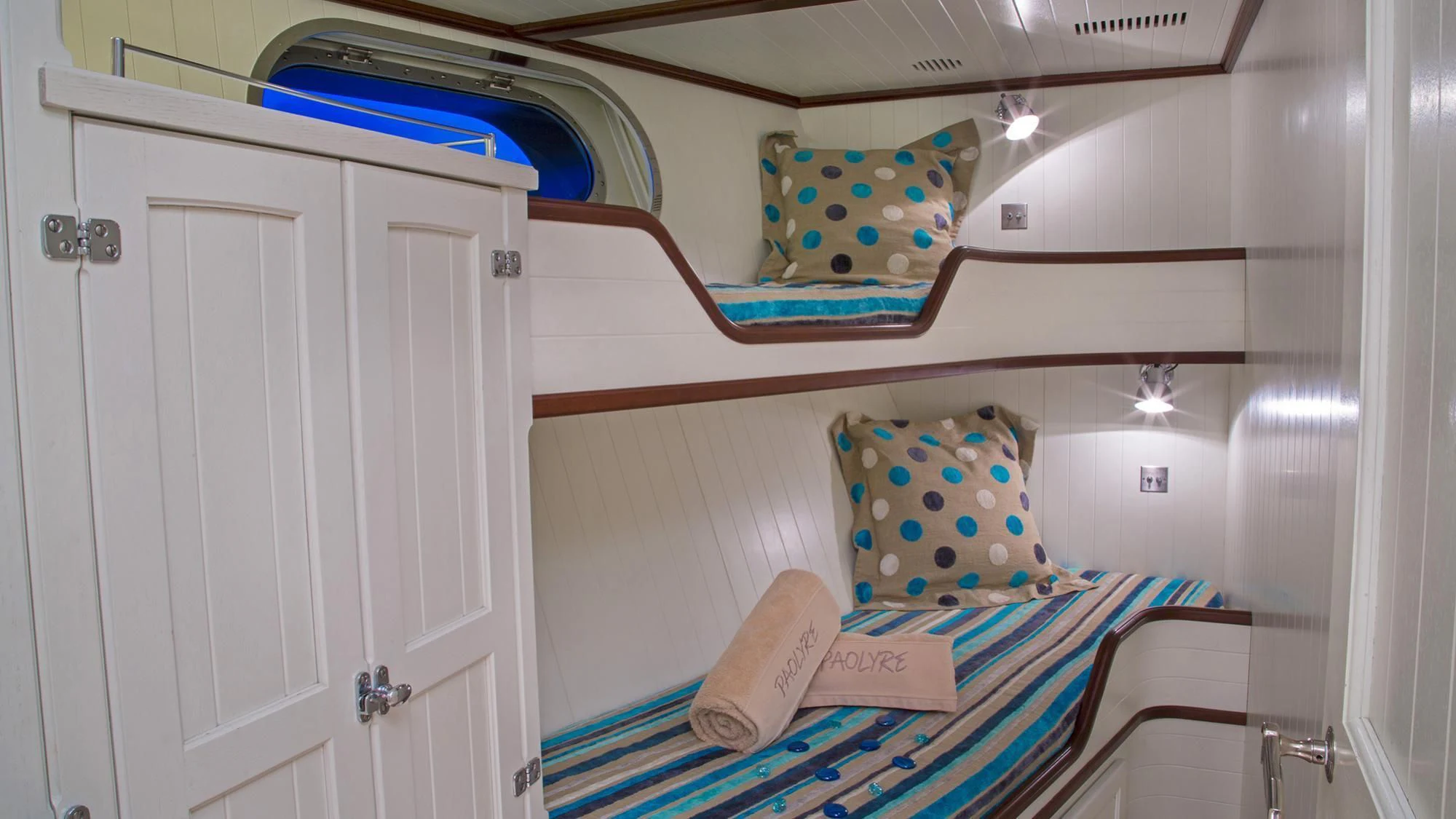 a bunk bed with blue and white pillows aboard PAOLYRE Yacht for Sale