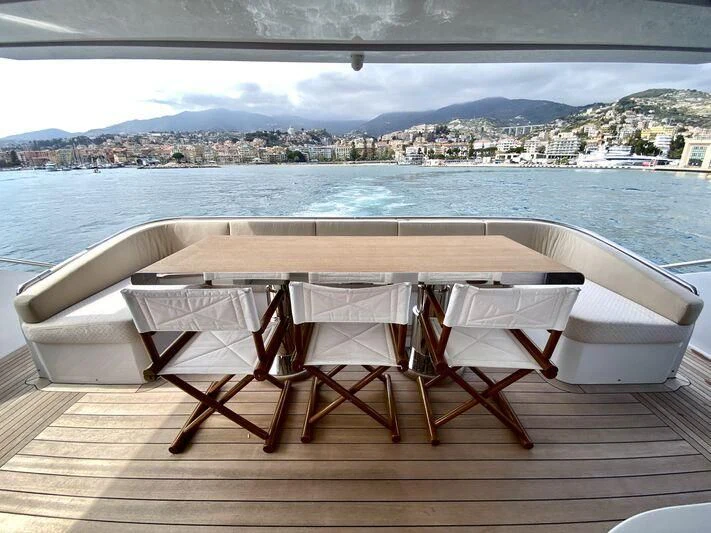 a table and chairs on a deck overlooking a body of water aboard MELT Yacht for Sale