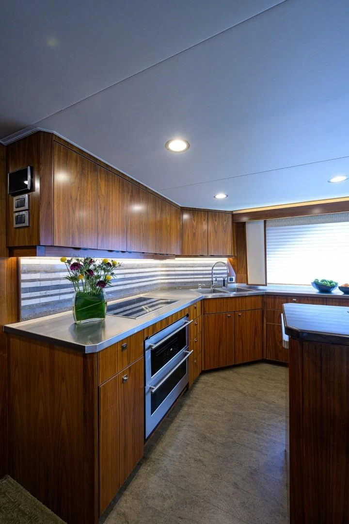 a kitchen with wooden cabinets aboard SWEETUMS Yacht for Sale