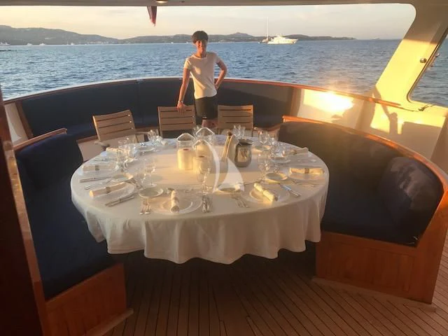 a person standing next to a table with glasses on it aboard SECRET LIFE Yacht for Sale