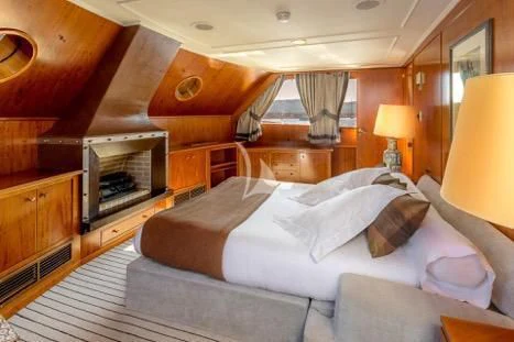 a room with a bed and a fireplace aboard SECRET LIFE Yacht for Sale