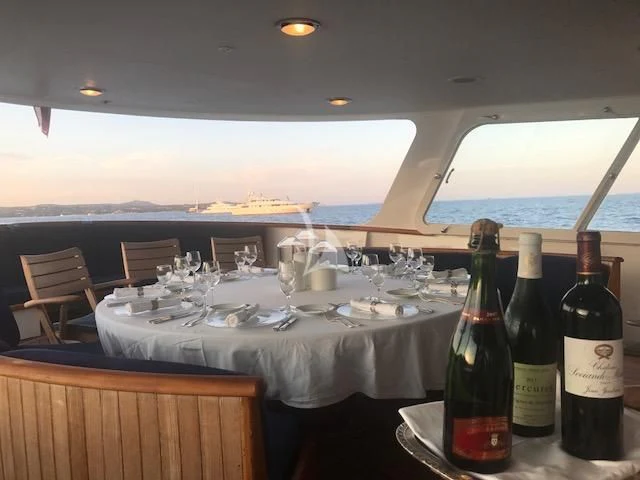 a table with wine bottles and glasses aboard SECRET LIFE Yacht for Sale