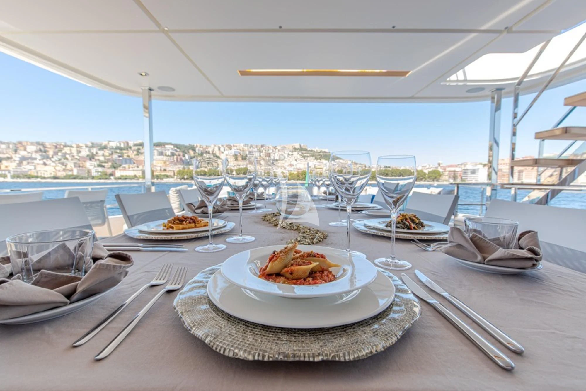 a table with plates of food and glasses on it aboard SOUTH Yacht for Sale