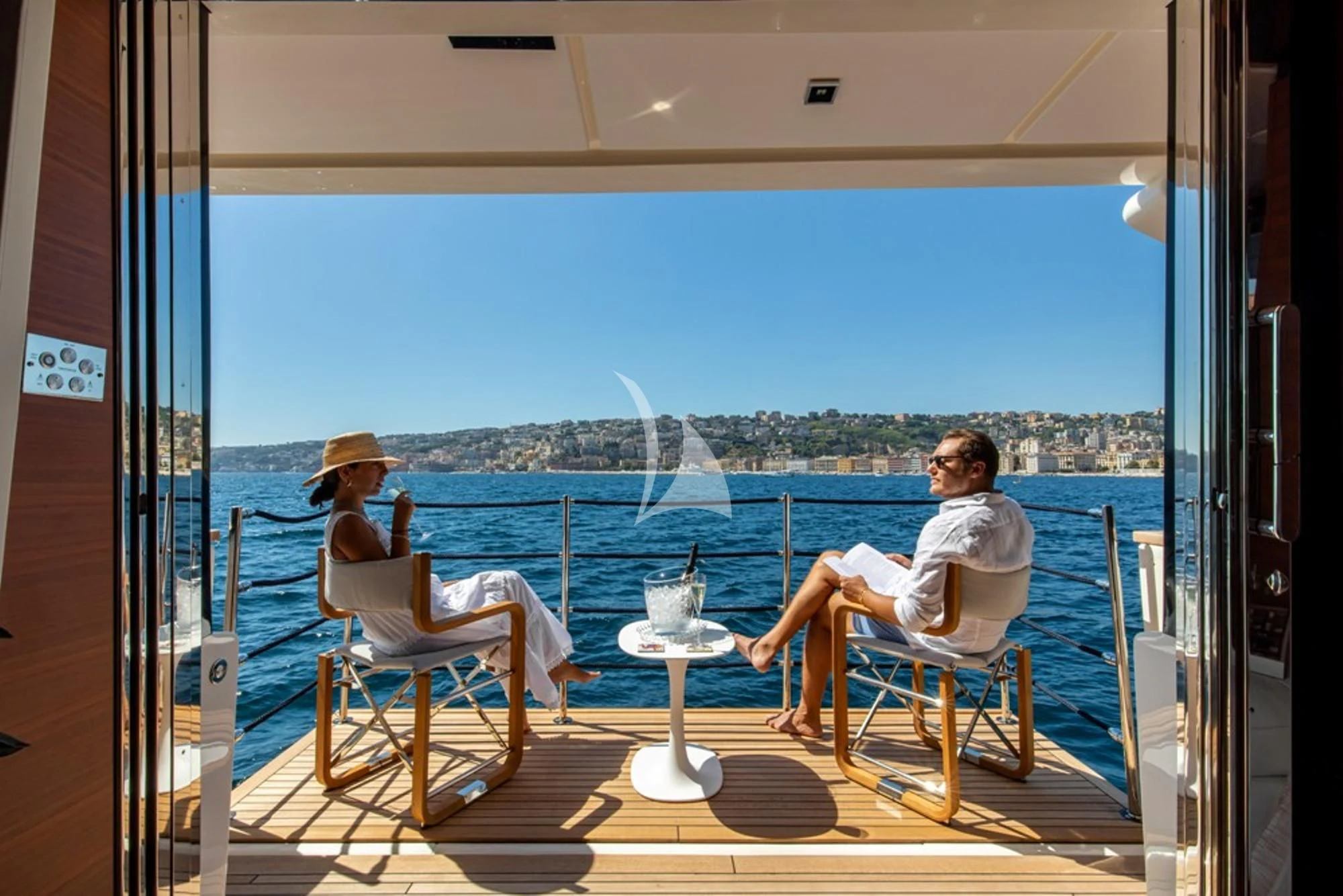 a couple sitting on chairs on a balcony overlooking a city aboard SOUTH Yacht for Sale