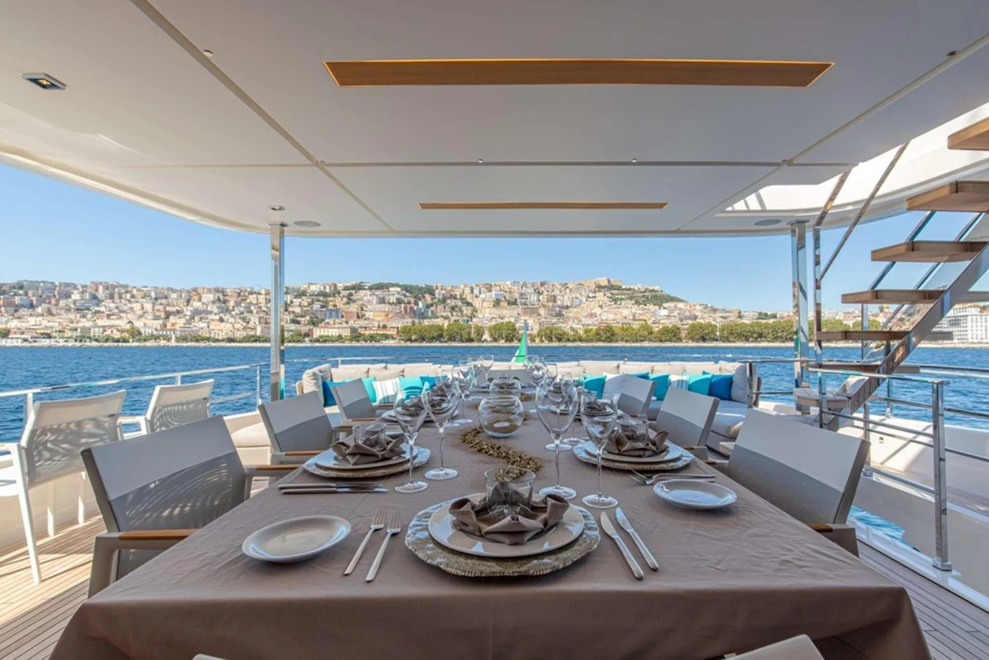 a table set for a meal on a deck overlooking a large body of water aboard SOUTH Yacht for Sale