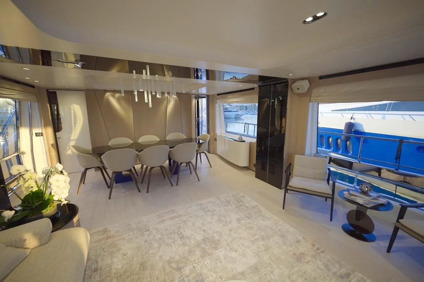 a room with a large window and a table with chairs and a television aboard GRANDE 27M Yacht for Sale