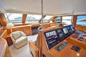 a room with a large window and a large wood table with a large window and a view of aboard CTC Yacht for Sale