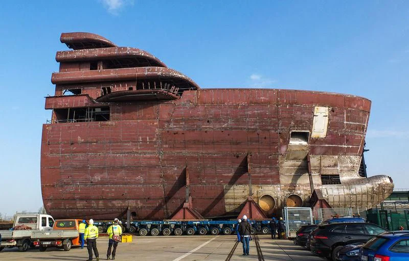 a large red building with a few people standing in front of it with Museum aan de Stroom in the background aboard SOLARIS Yacht for Sale