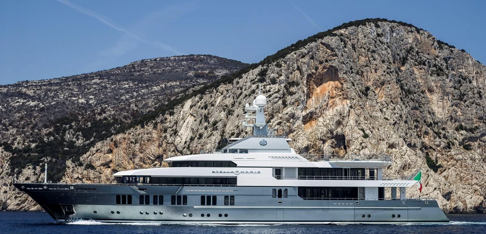 a cruise ship in front of a mountain aboard STELLA MARIS Yacht for Sale