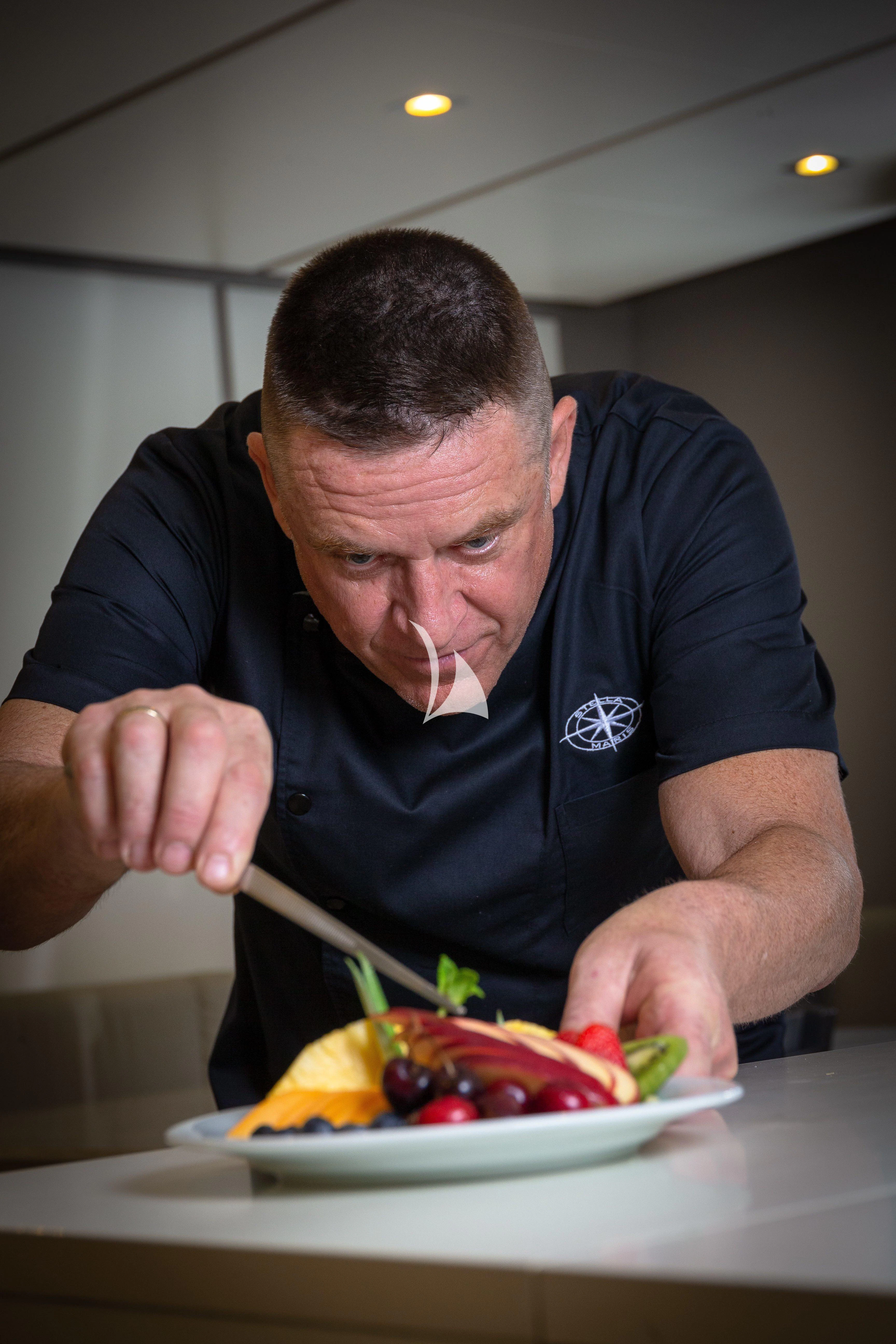 a man eating a bowl of fruit aboard STELLA MARIS Yacht for Sale