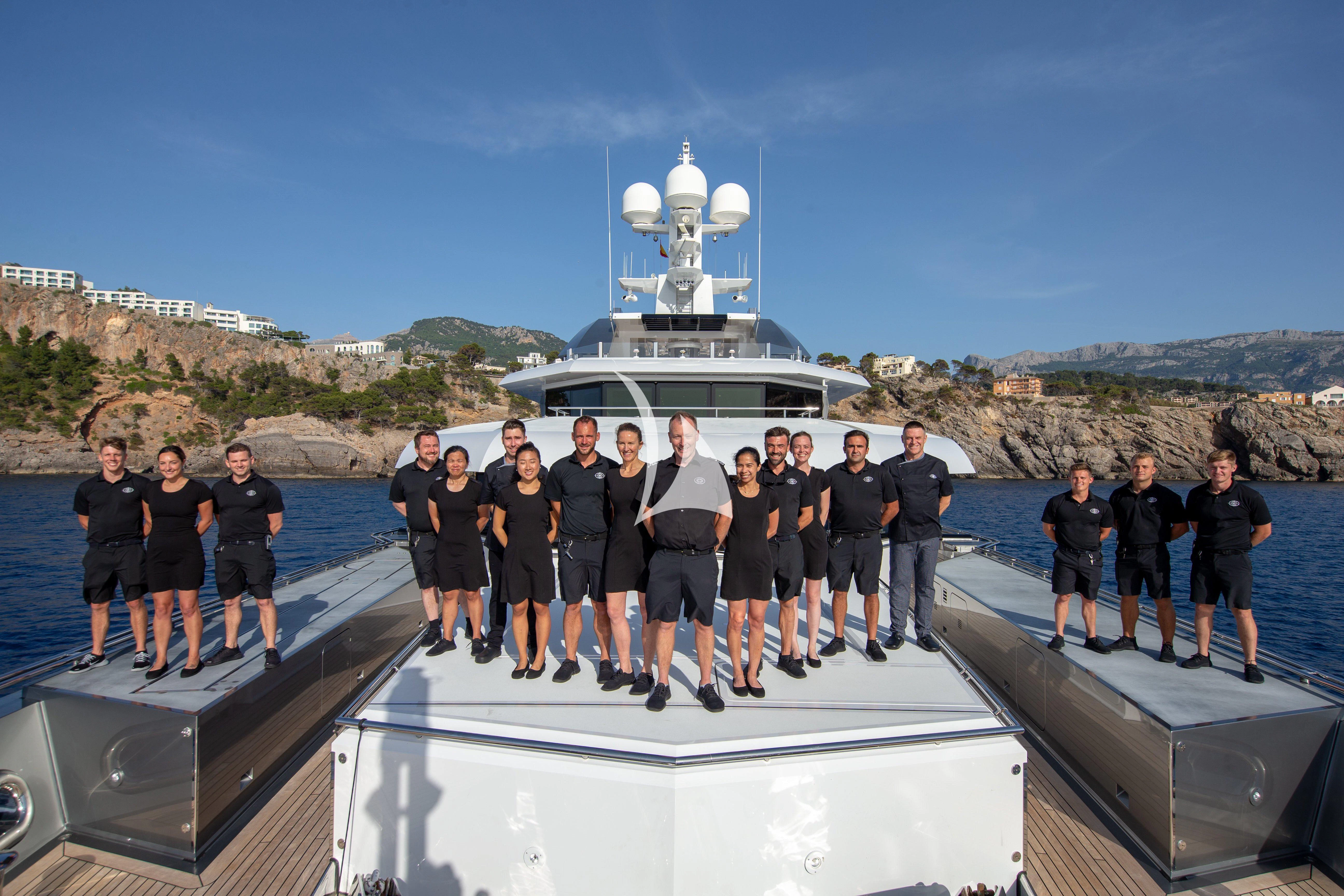 a group of people posing for a photo in front of a ship aboard STELLA MARIS Yacht for Sale