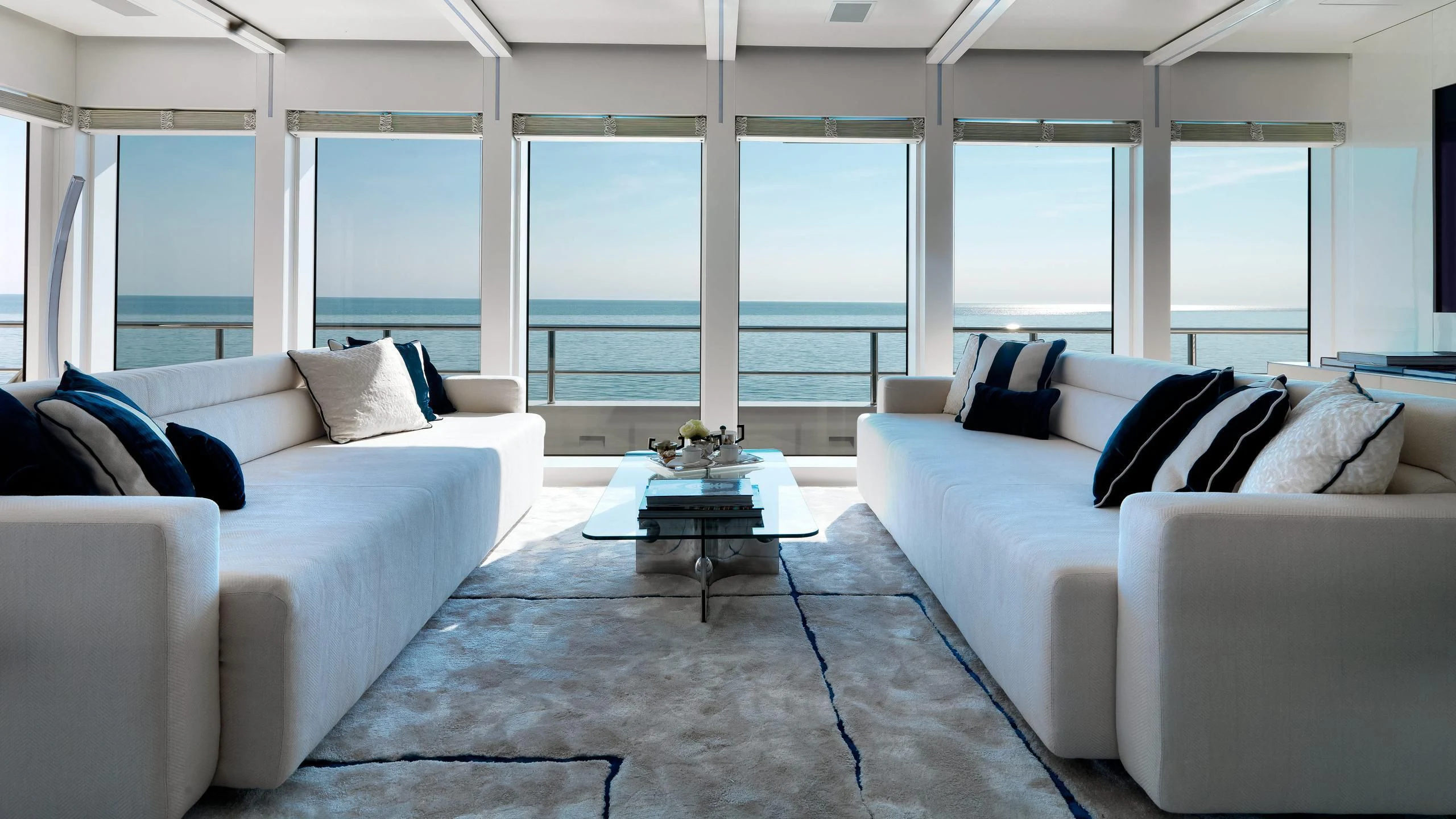 a room with white couches and a coffee table aboard STELLA MARIS Yacht for Sale