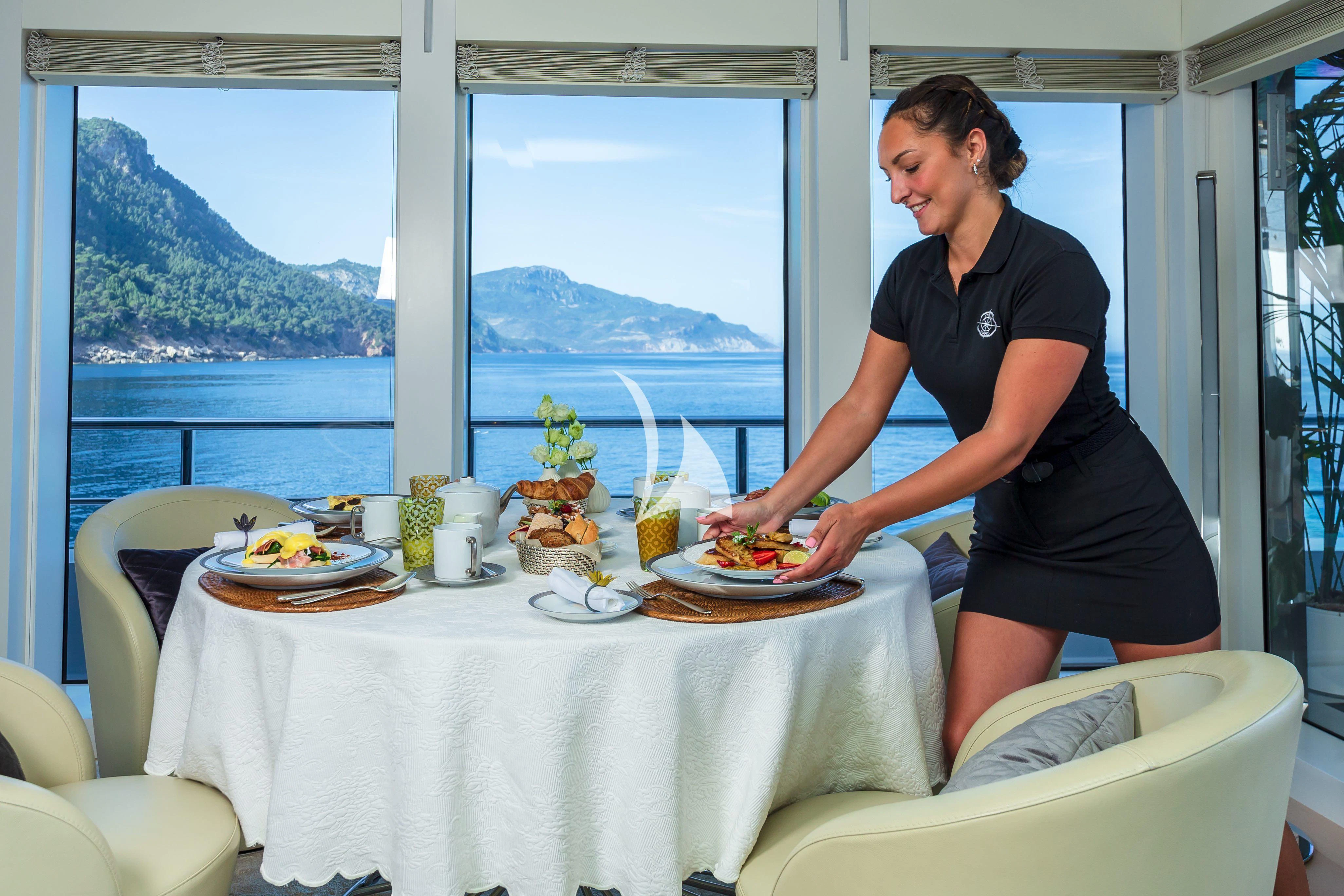 a person standing at a table with food on it aboard STELLA MARIS Yacht for Sale