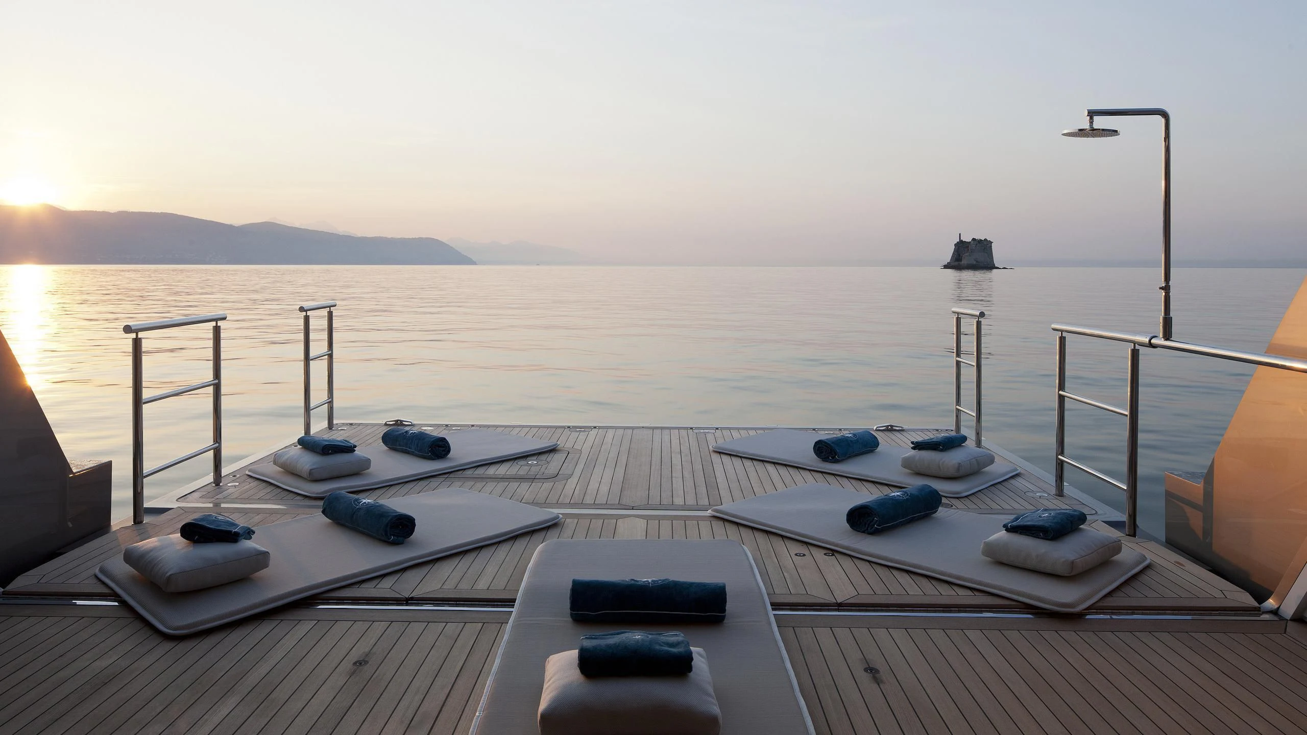 a deck with a table and chairs on it by the water aboard STELLA MARIS Yacht for Sale
